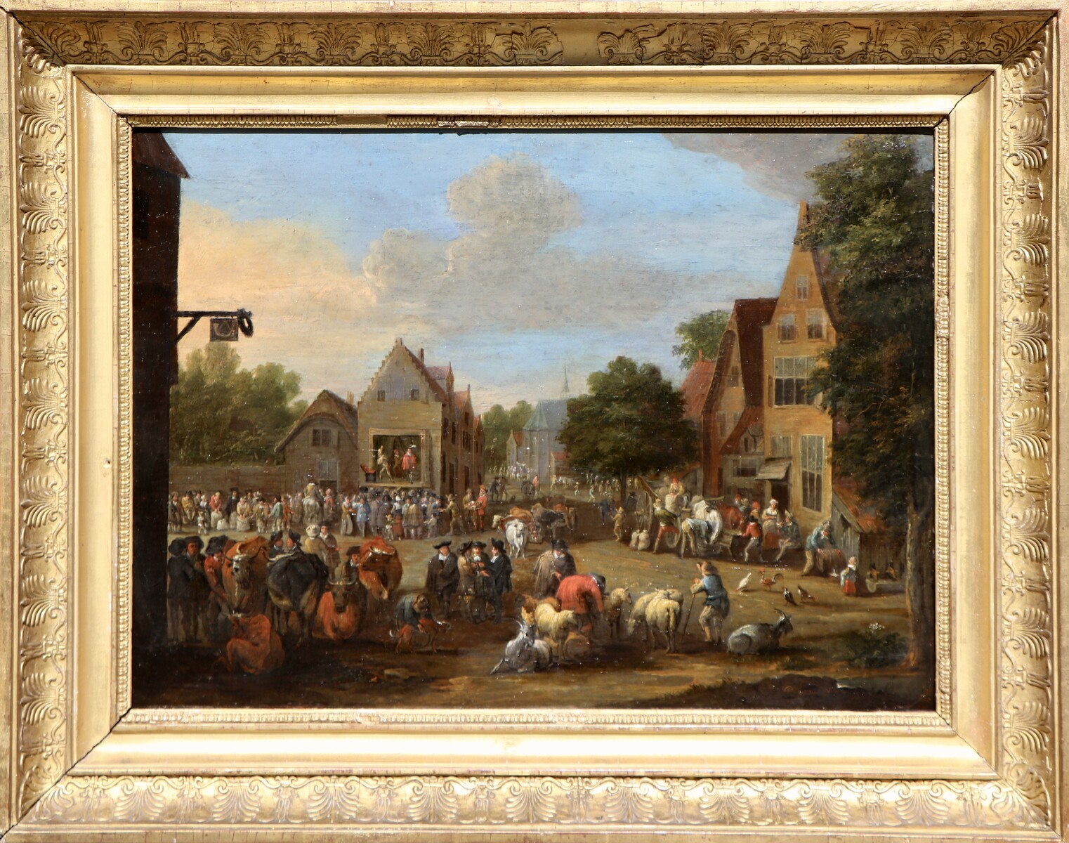 A cattle market, a theatre company performing in the background