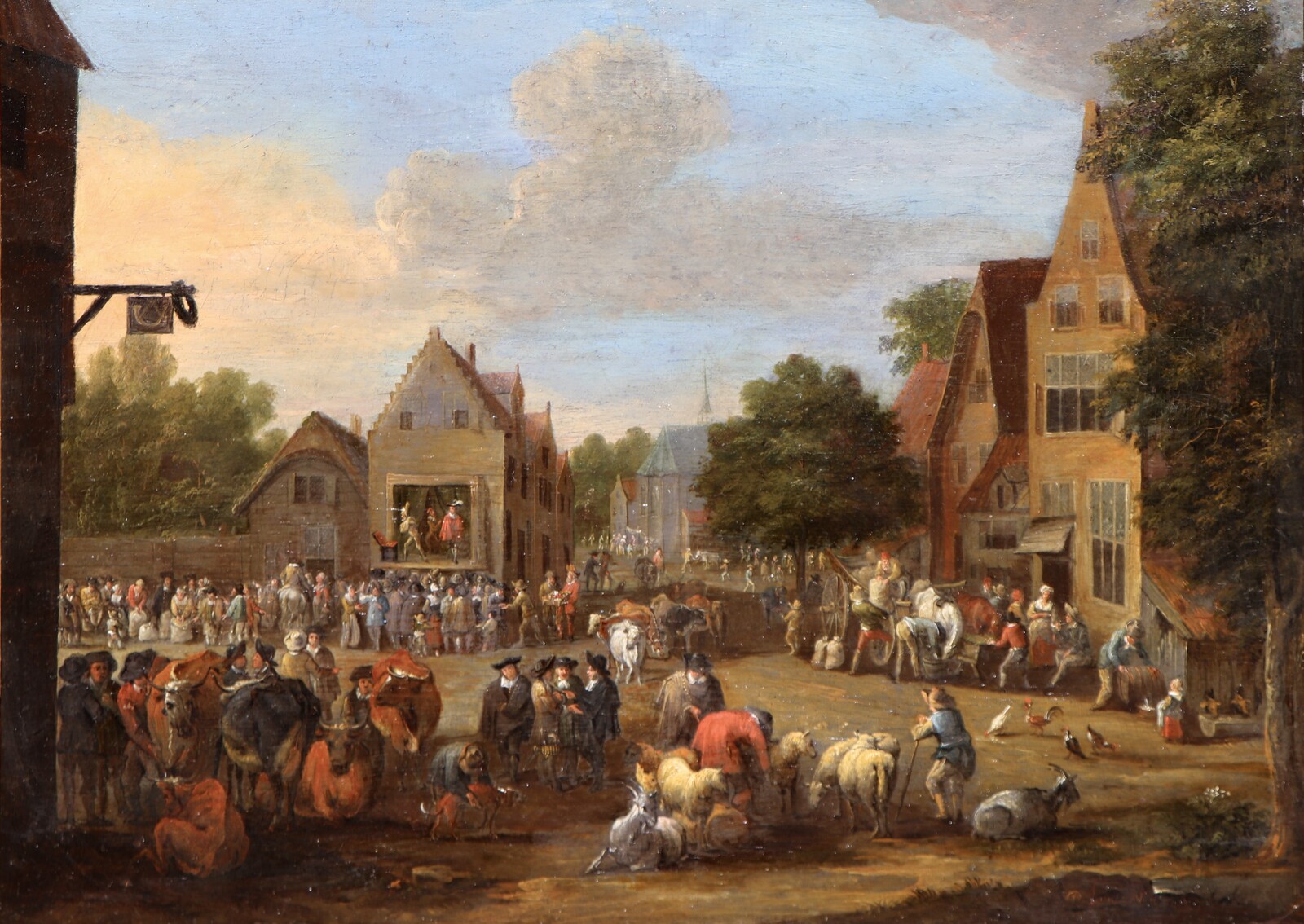 A cattle market, a theatre company performing in the background