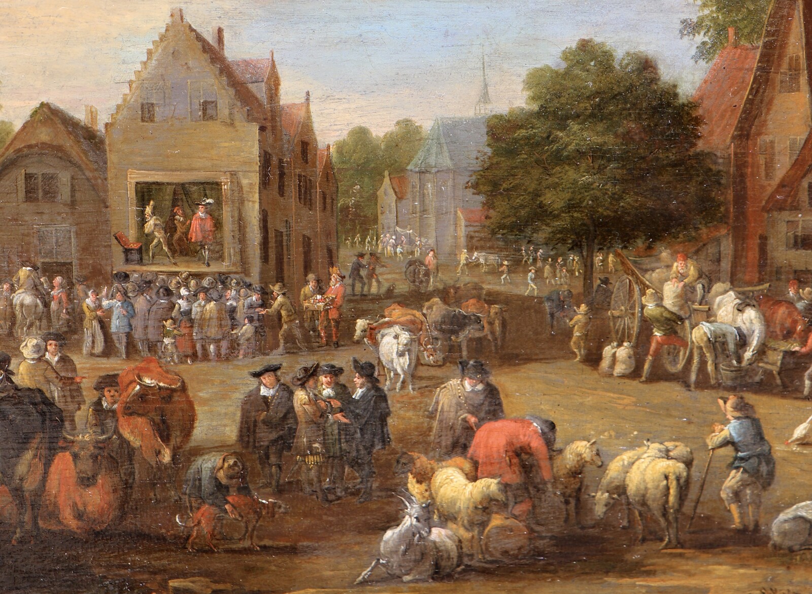 A cattle market, a theatre company performing in the background