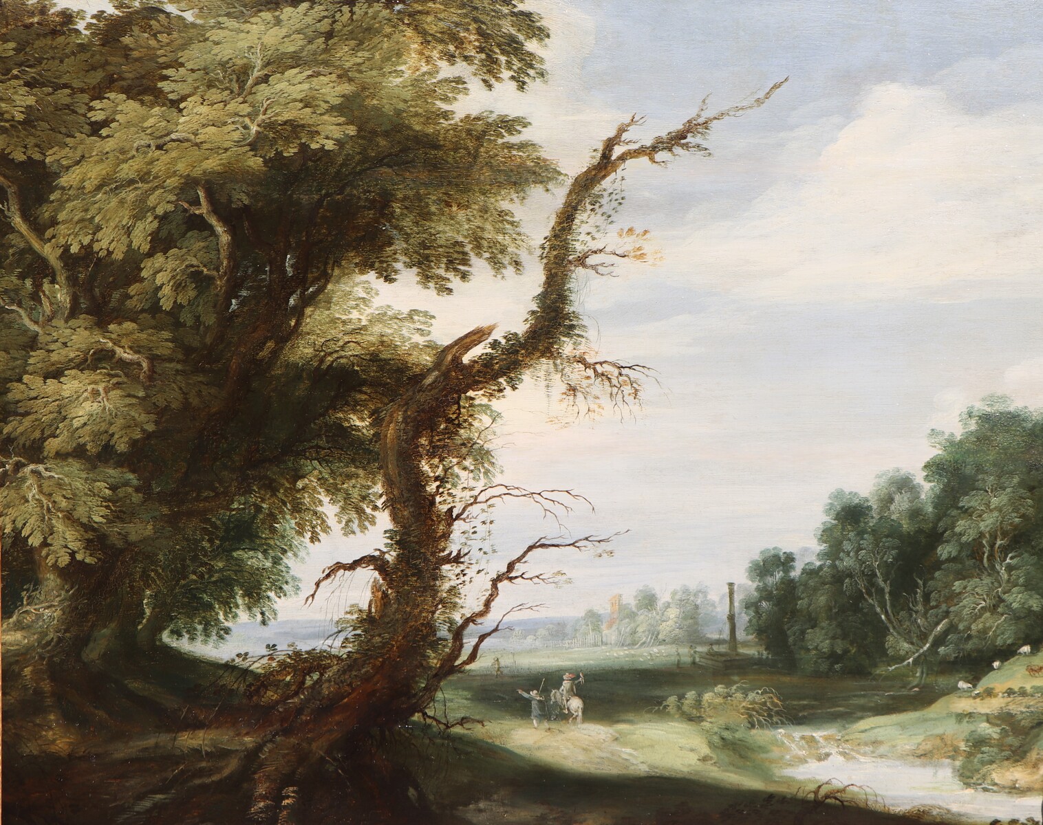 A falconer in a partly wooded landscape