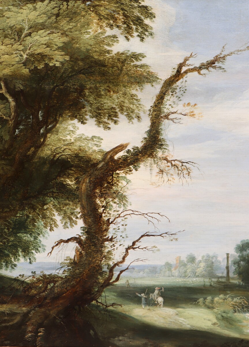 A falconer in a partly wooded landscape