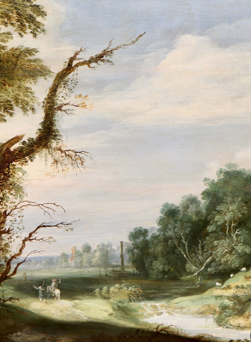 A falconer in a partly wooded landscape