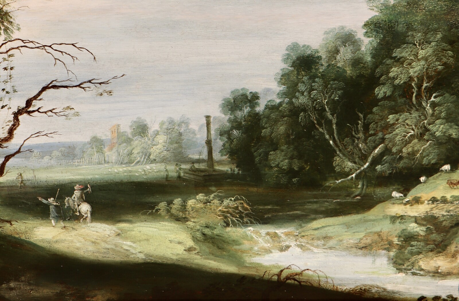 A falconer in a partly wooded landscape