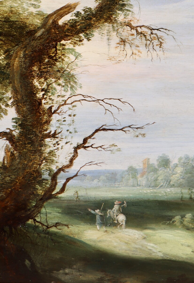 A falconer in a partly wooded landscape