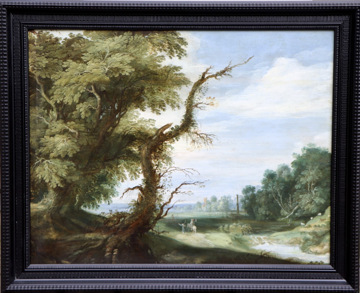 A falconer in a partly wooded landscape