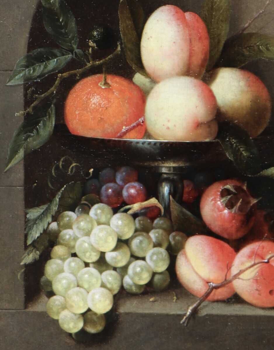 A fruit still life in a silver tazza standing in a stone niche