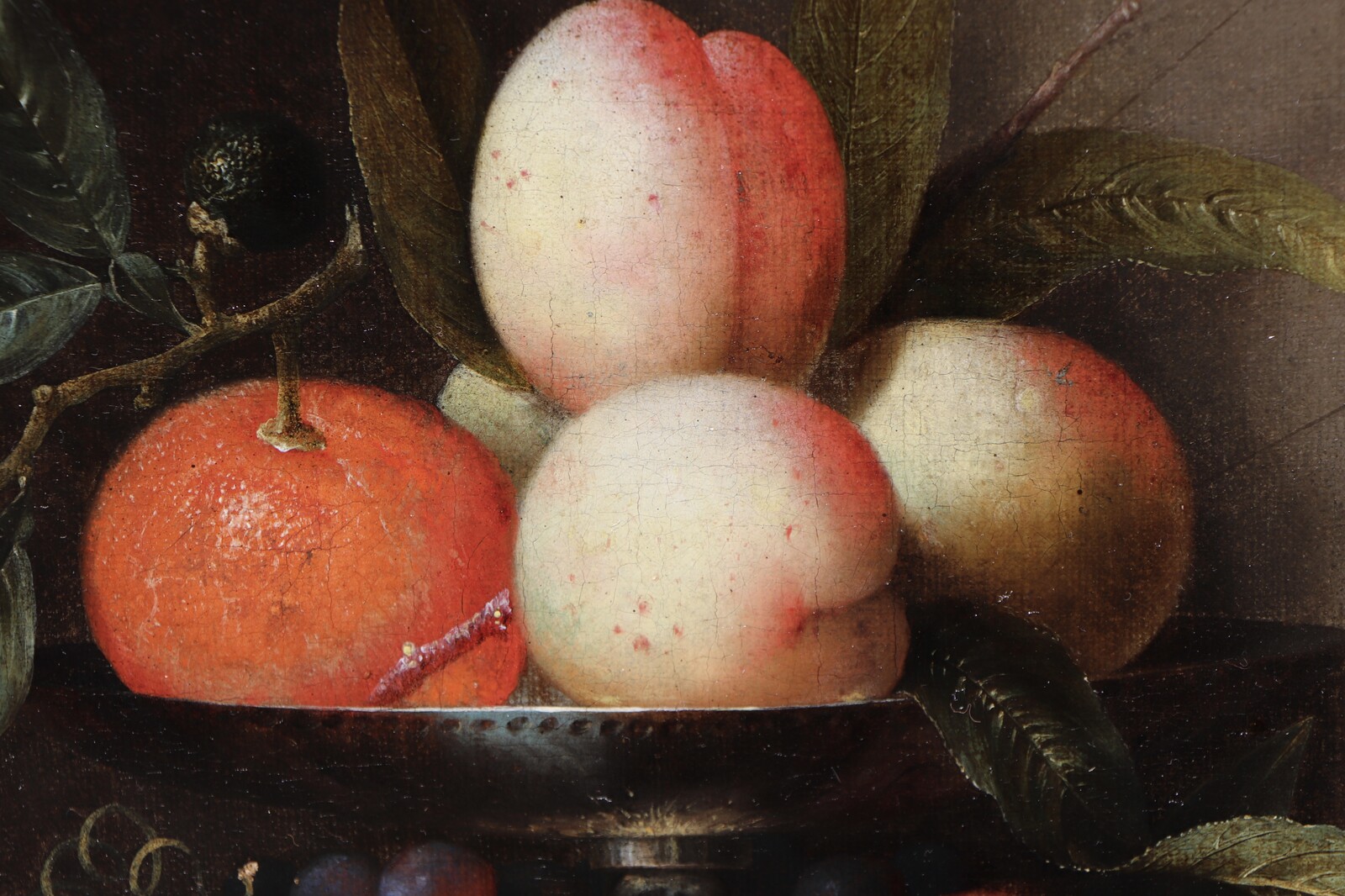 A fruit still life in a silver tazza standing in a stone niche