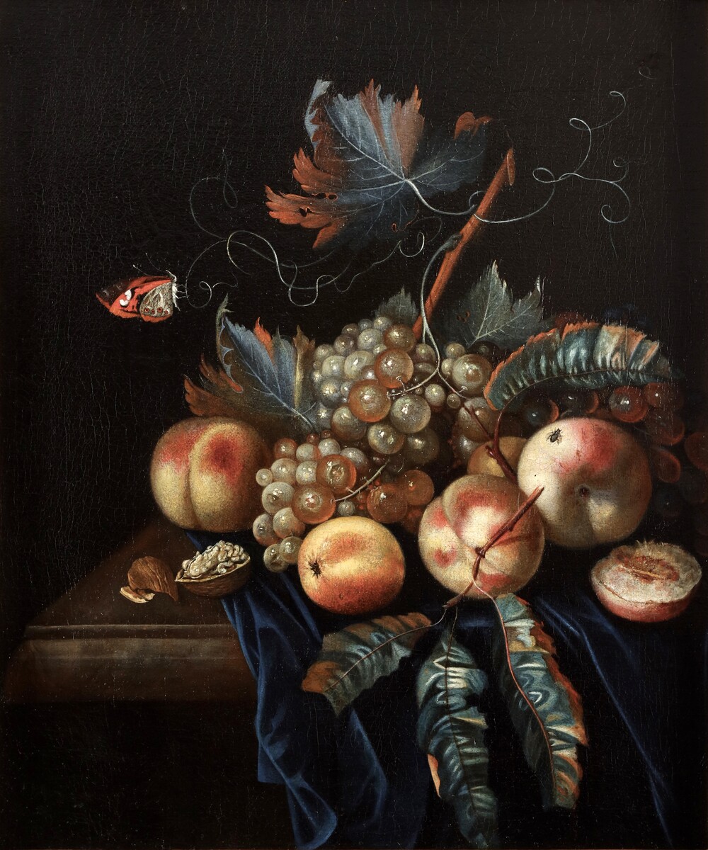 A fruit still life with peaches and grapes, a butterfly and a fly