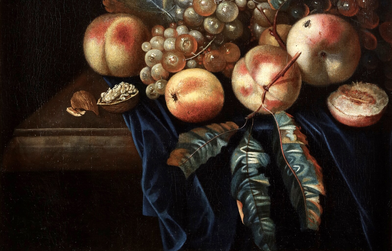 A fruit still life with peaches and grapes, a butterfly and a fly