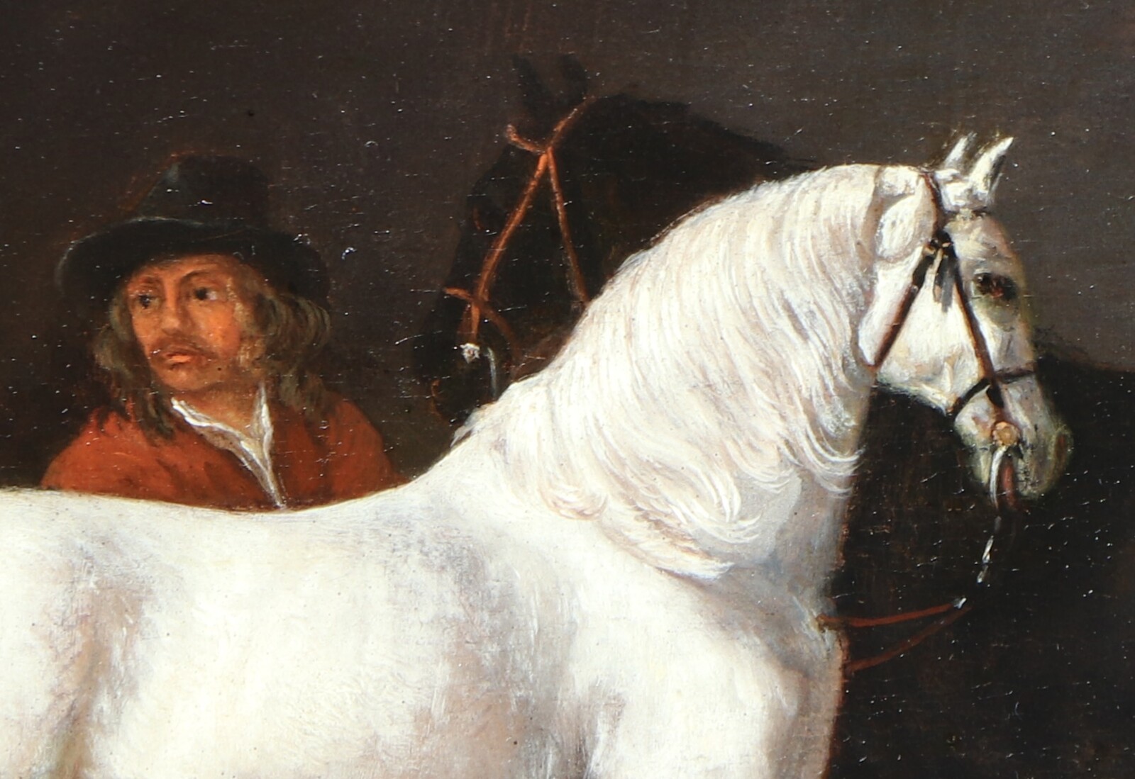 Two horses and a groom in a stable interior