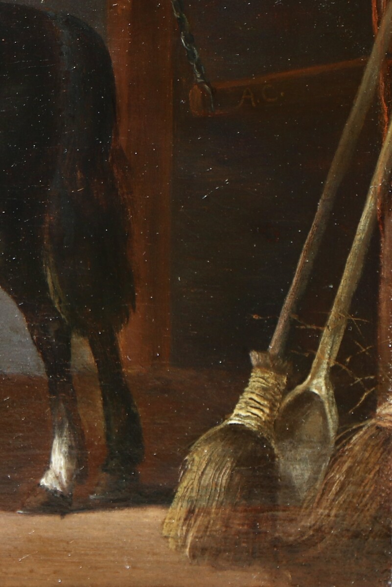 Two horses and a groom in a stable interior