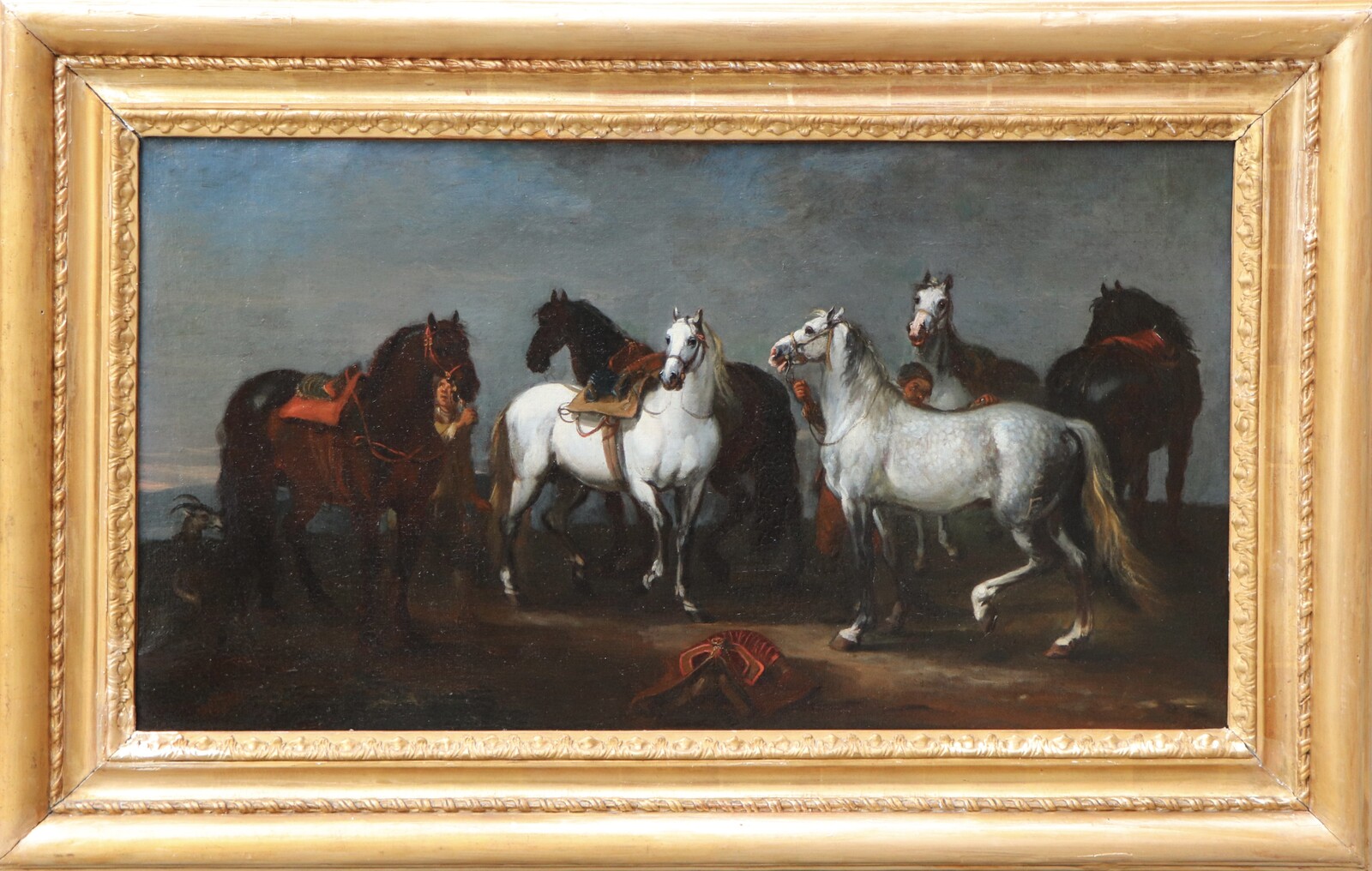 Two stable boys looking after six horses