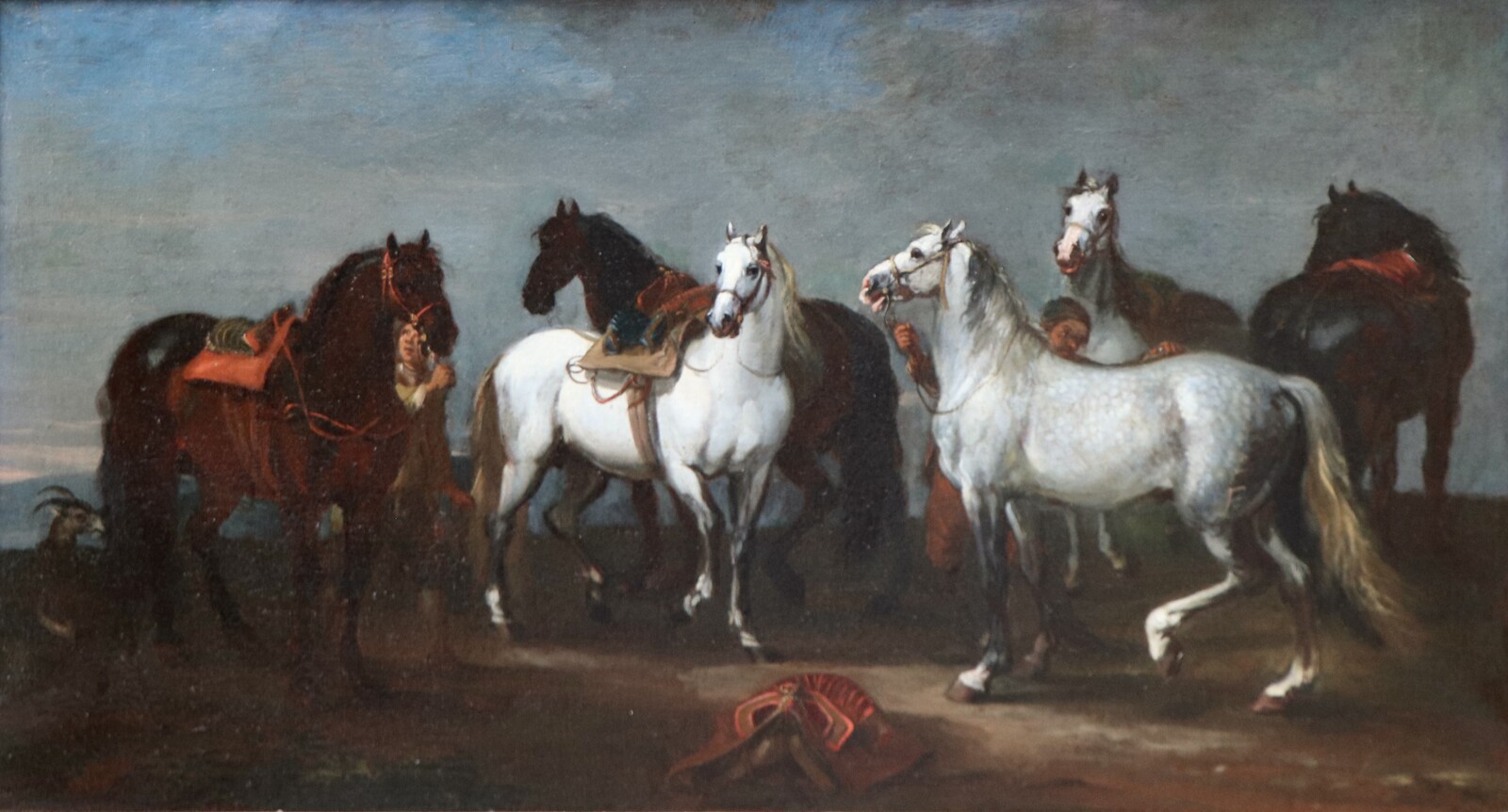 Two stable boys looking after six horses
