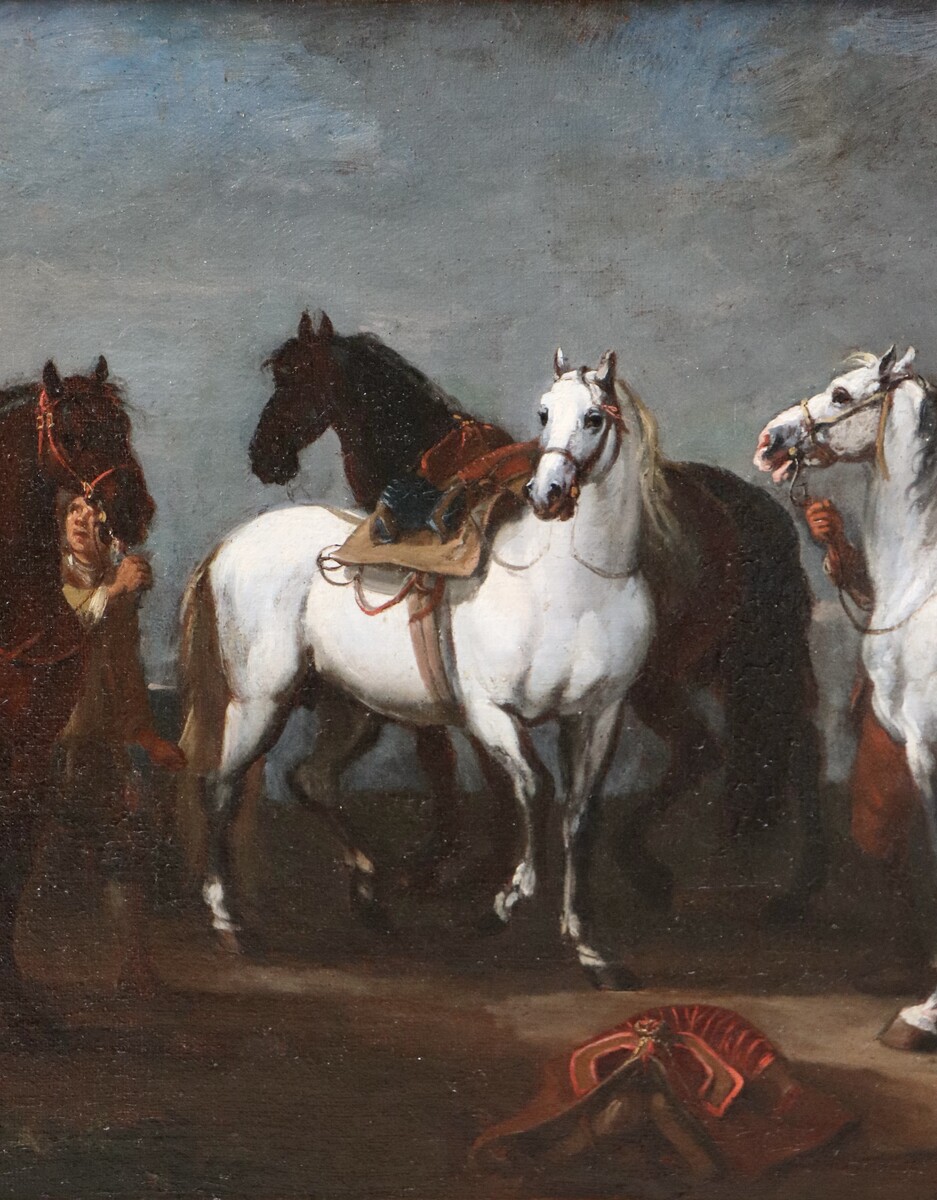 Two stable boys looking after six horses
