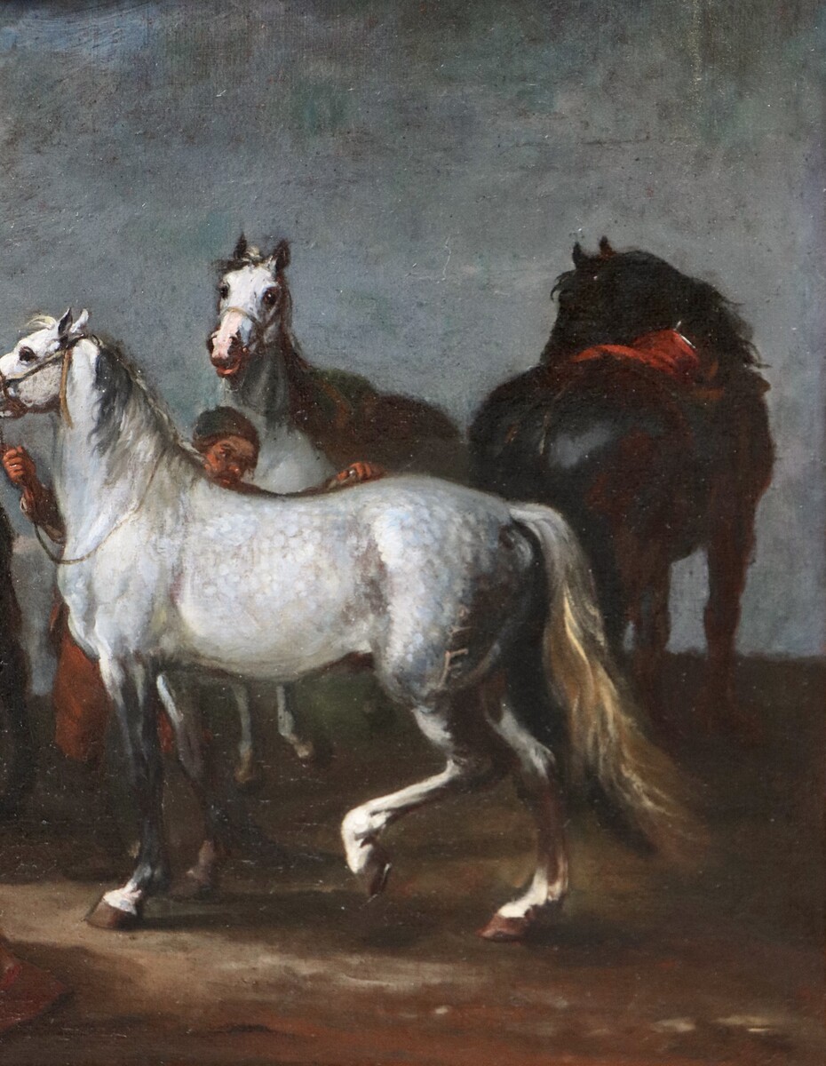 Two stable boys looking after six horses