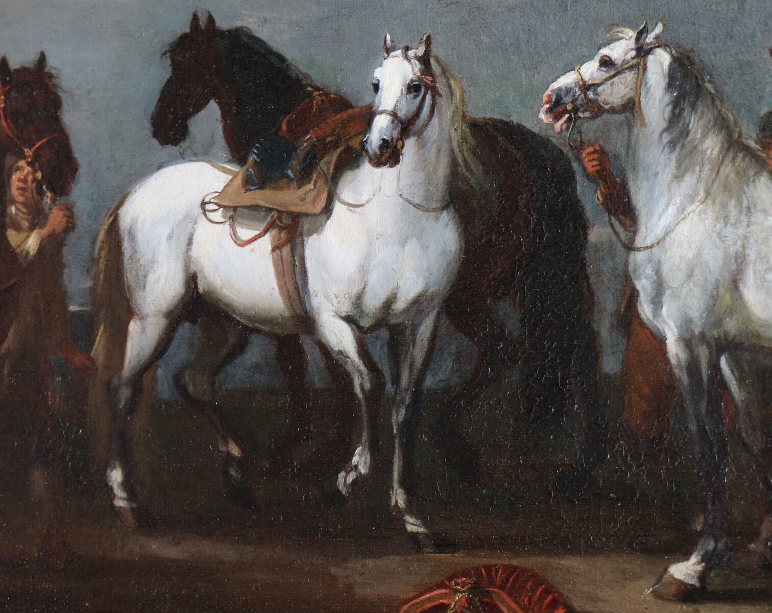 Two stable boys looking after six horses