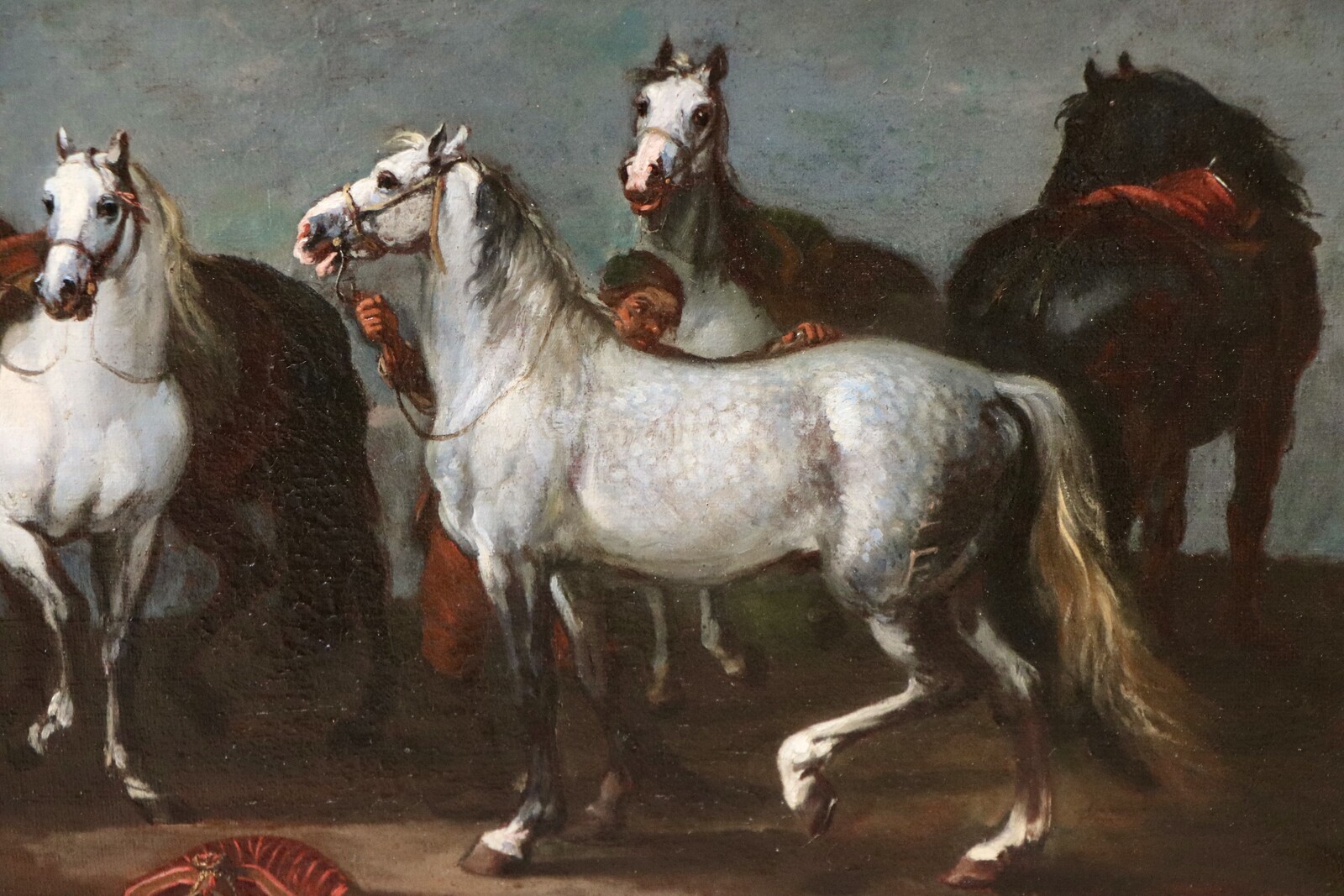 Two stable boys looking after six horses